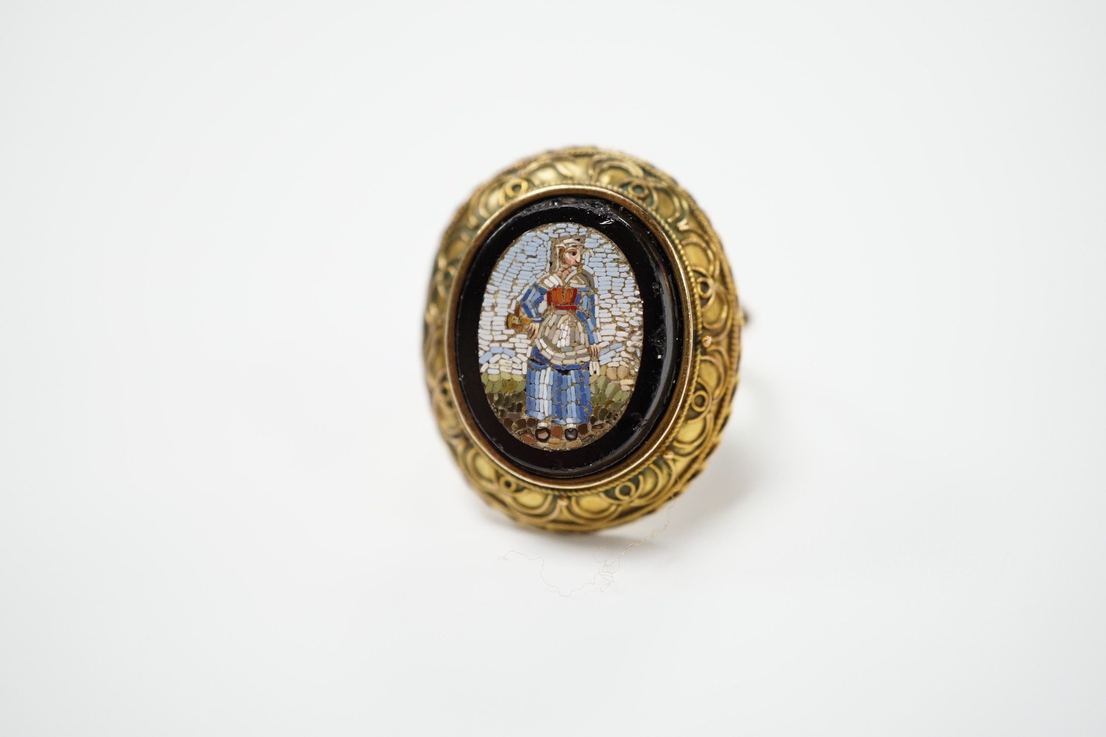 A 19th century yellow metal and oval micro mosaic set ring, depicting a warrior, size O.